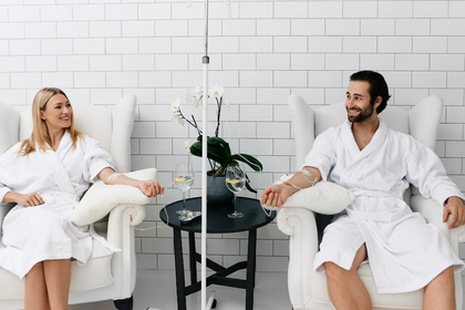 A man and a woman are sitting in chairs talking to each other.