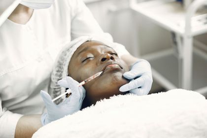 A woman is getting an injection in her face at a beauty salon.
