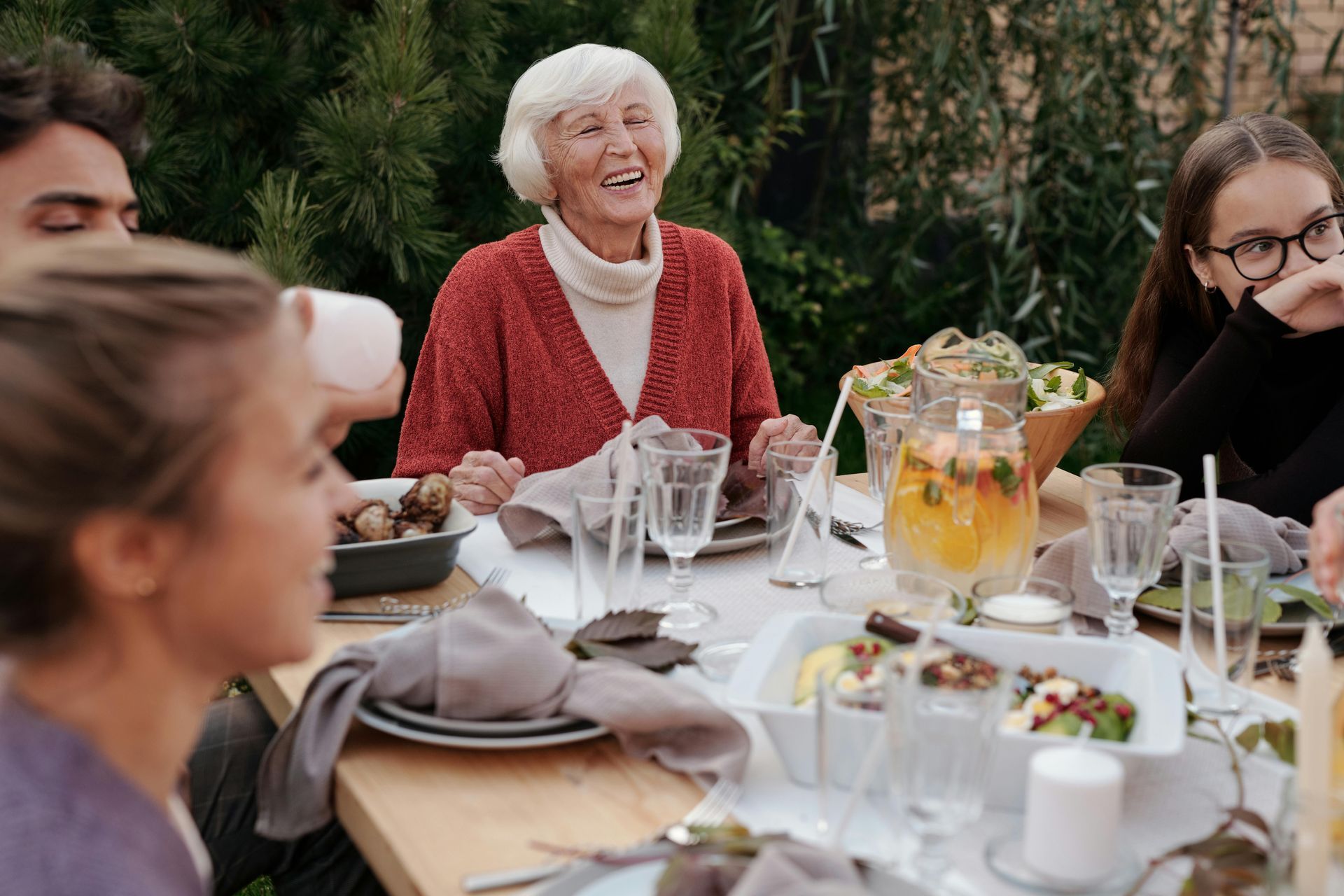 A group of people are sitting around a table eating food.