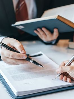Several hands with pens