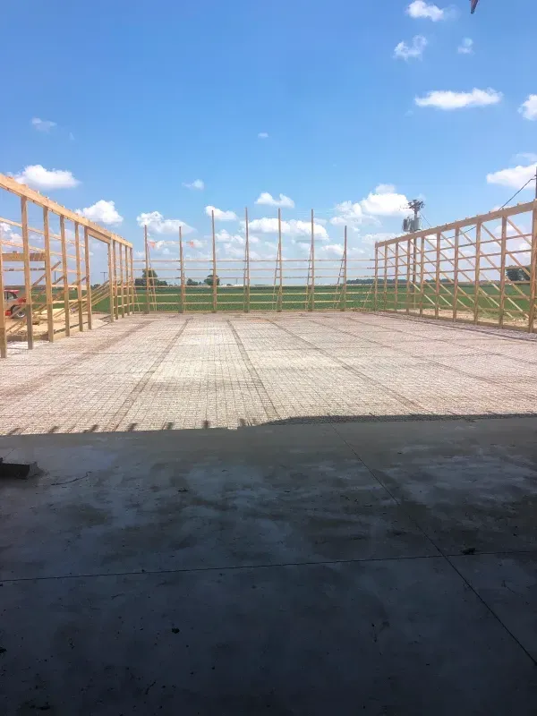 Interior view of a building under construction, showing wooden frames, wiring, and ductwork.