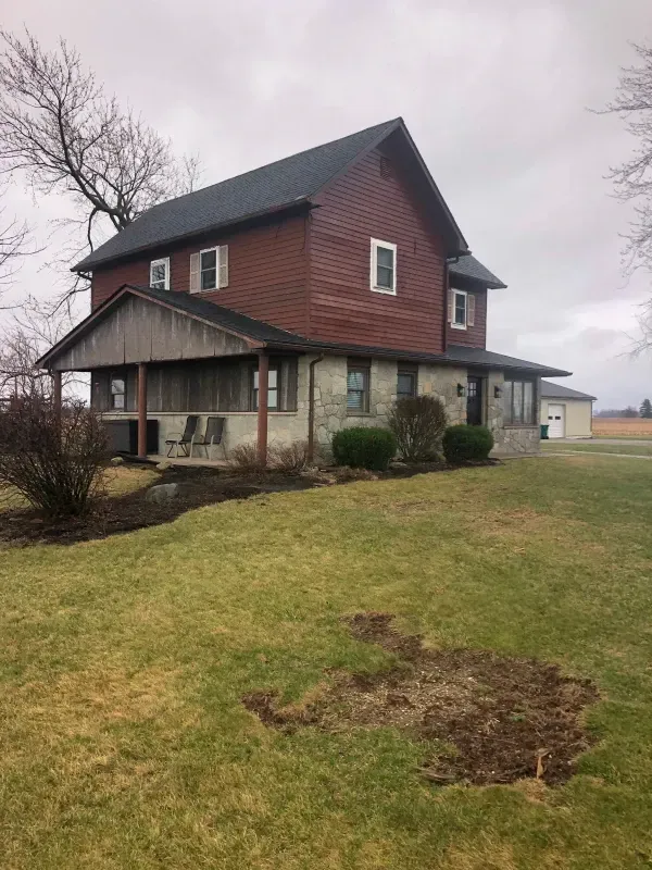 Luxurious bedroom with king bed, bench, rug, sofa, armchair, and lamps.