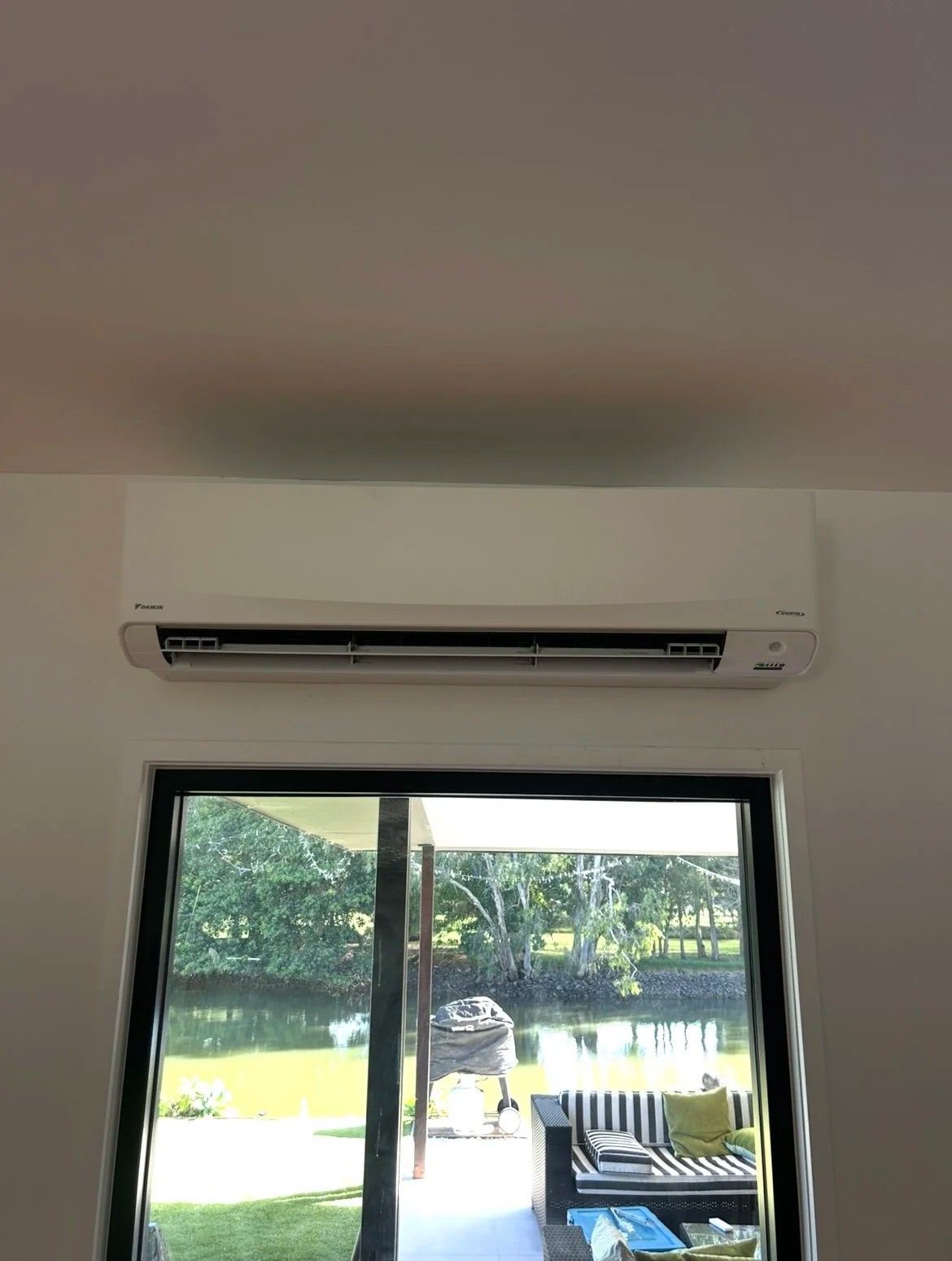 Wall-mounted White Air Conditioner Above a Window — BTM Electrical & Air in Burleigh Waters, QLD