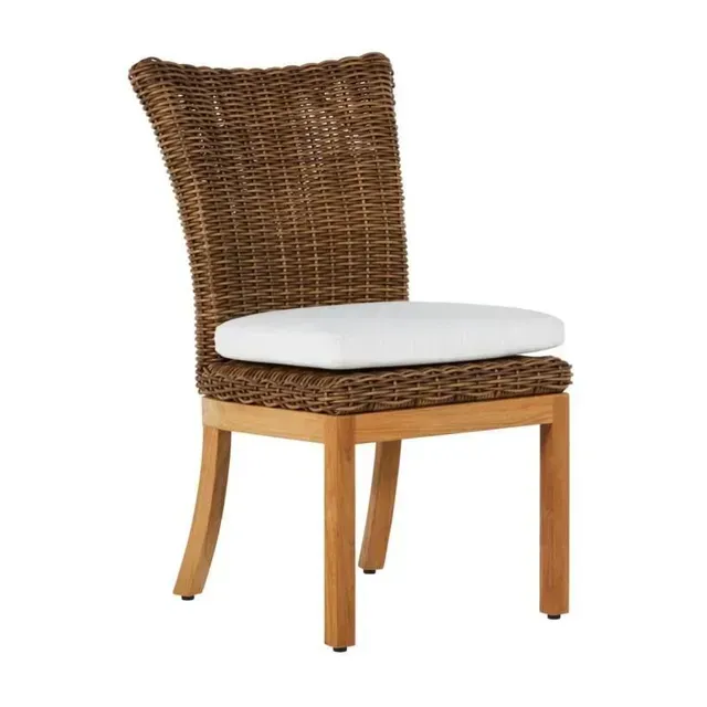 Woven brown chair with a white cushion on a wooden frame, likely for outdoor use.