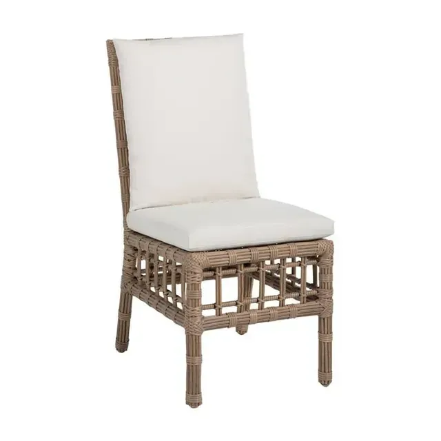Woven outdoor dining chair with cream cushions.