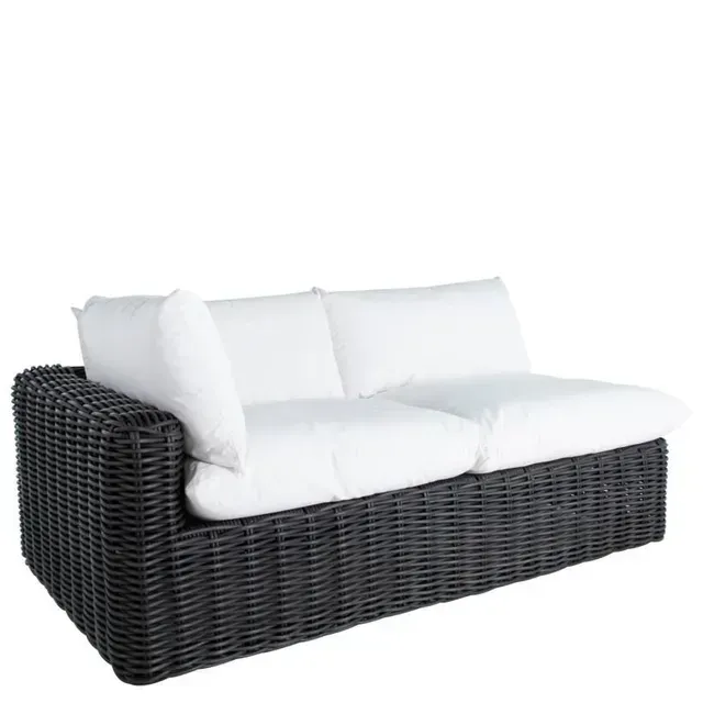 Charcoal wicker outdoor sectional sofa with white cushions.