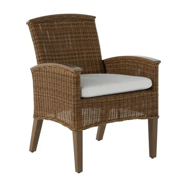 Wicker armchair with brown weave, wooden legs, and a white cushion.