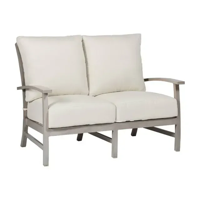 Two-seater outdoor sofa with light cushions and light-colored wooden frame.