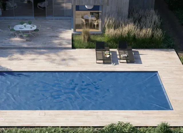 Modern outdoor space with pool, wooden deck, and lounge chairs.