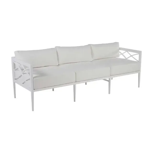 White outdoor sofa with three cushions and lattice side detail.