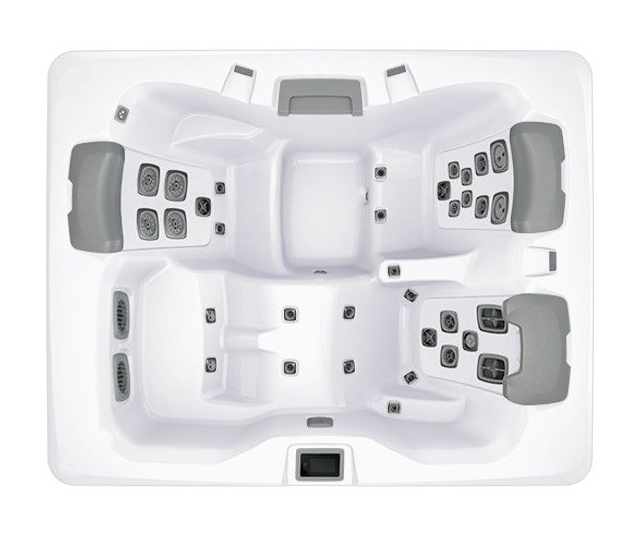 Overhead view of a white hot tub with grey headrests and control panels; contains multiple seating areas and jets.
