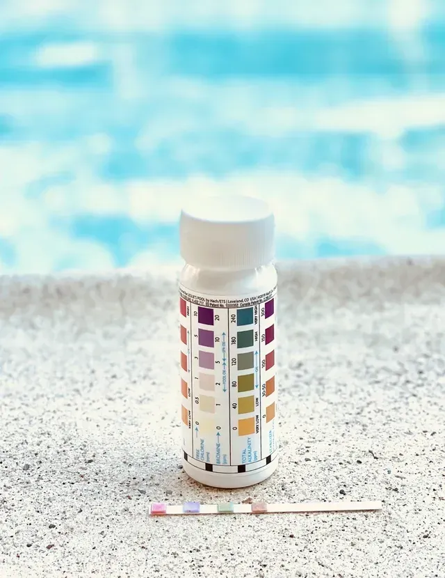 Pool water test kit with color chart and test strip.
