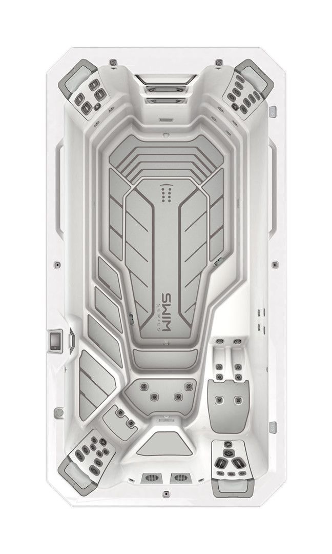 Top-down view of a white swim spa with contoured seats and multiple control panels.