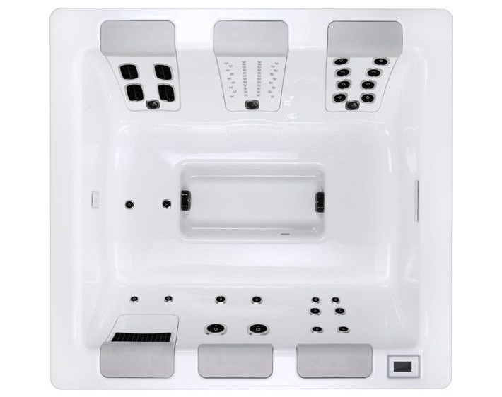 Overhead view of a white hot tub interior, showing jets and seating.