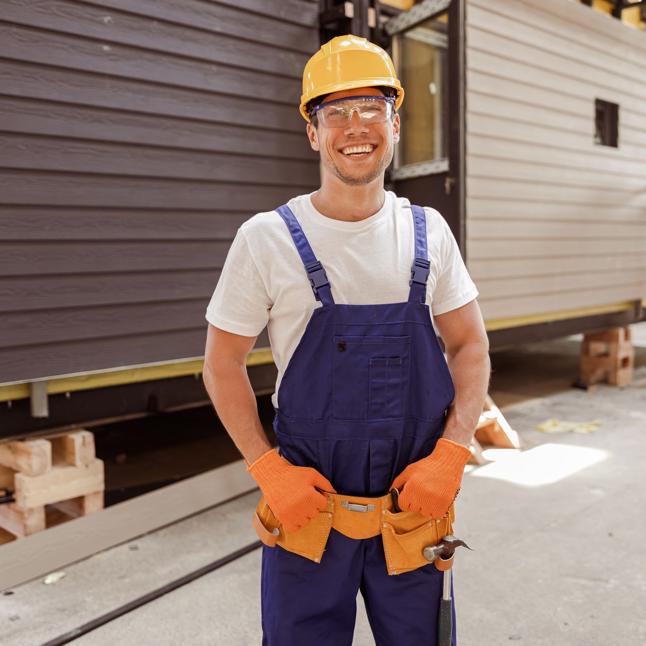 cheerful male builder standing at construction site
