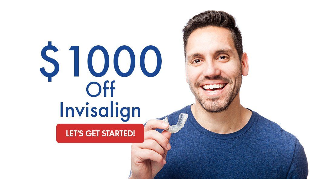 Young guy smiling holding Invisalign tray