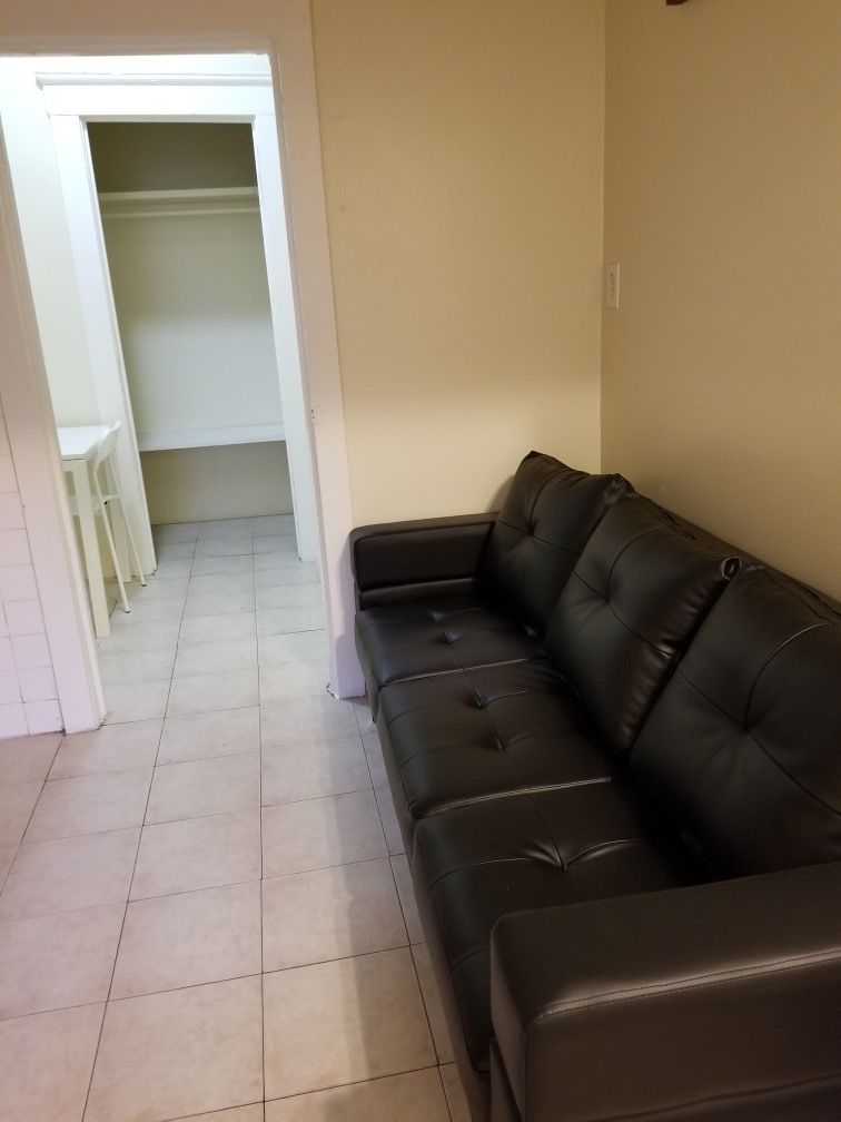 There is a black couch in the middle of the room.
