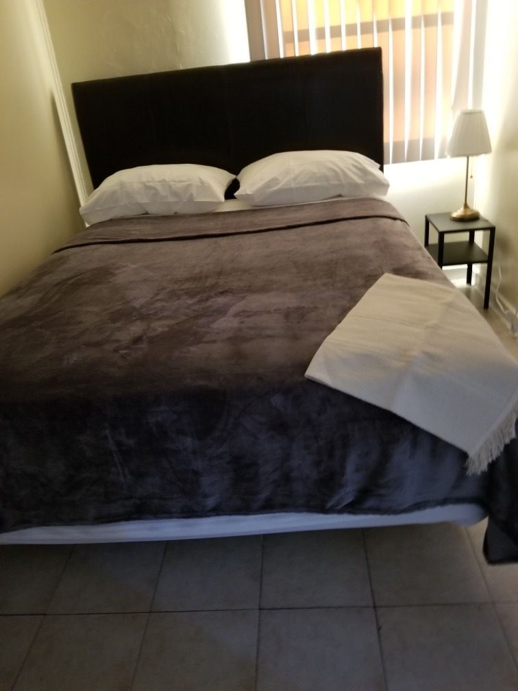 A bedroom with a bed and a lamp