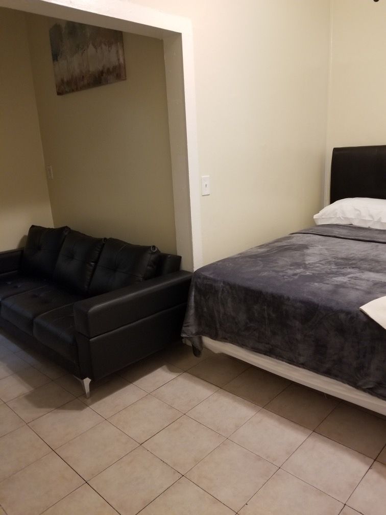 A bedroom with a couch and a bed in it