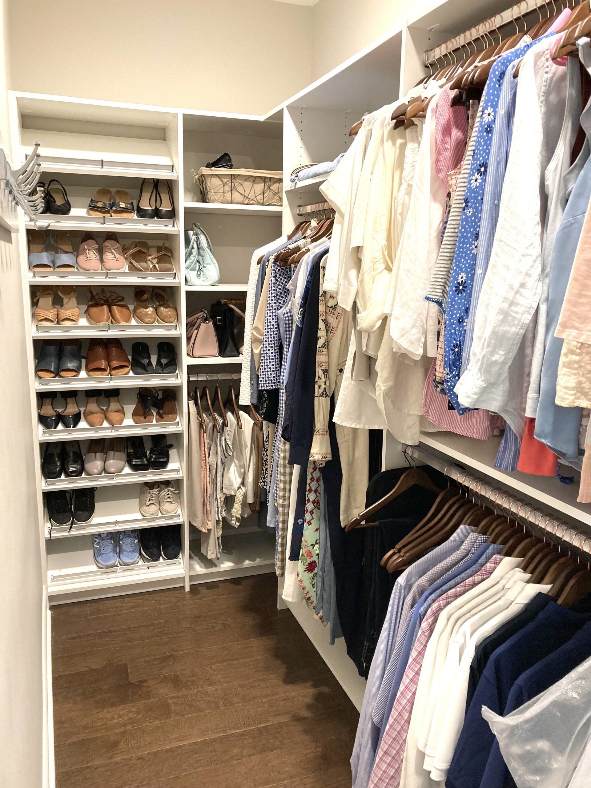 A walk in closet filled with lots of clothes and shoes.