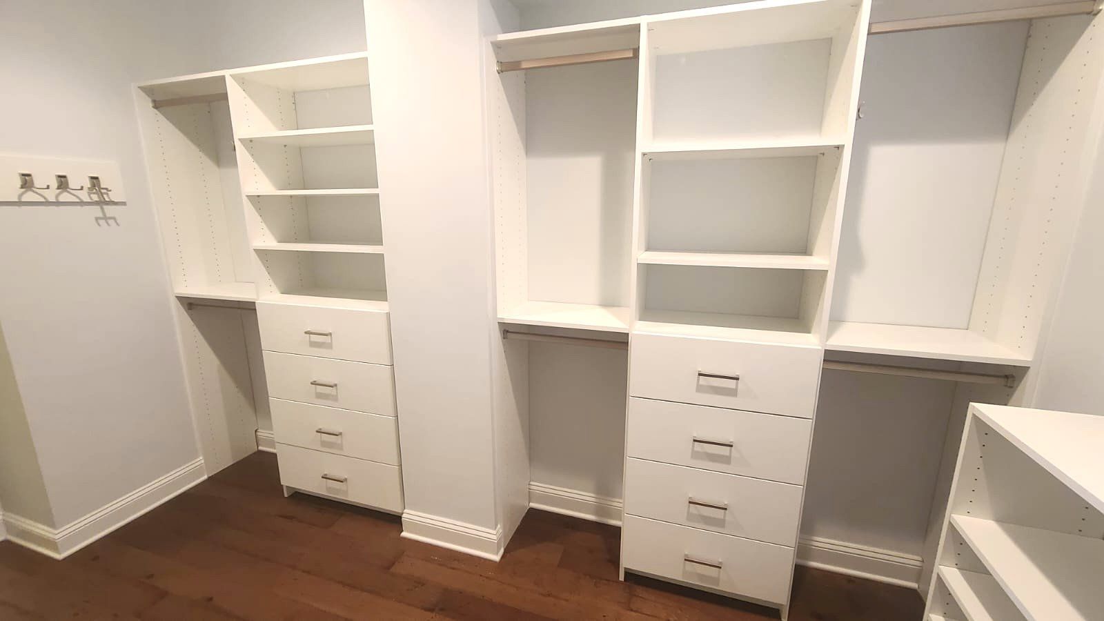 A walk in closet with lots of shelves and drawers.