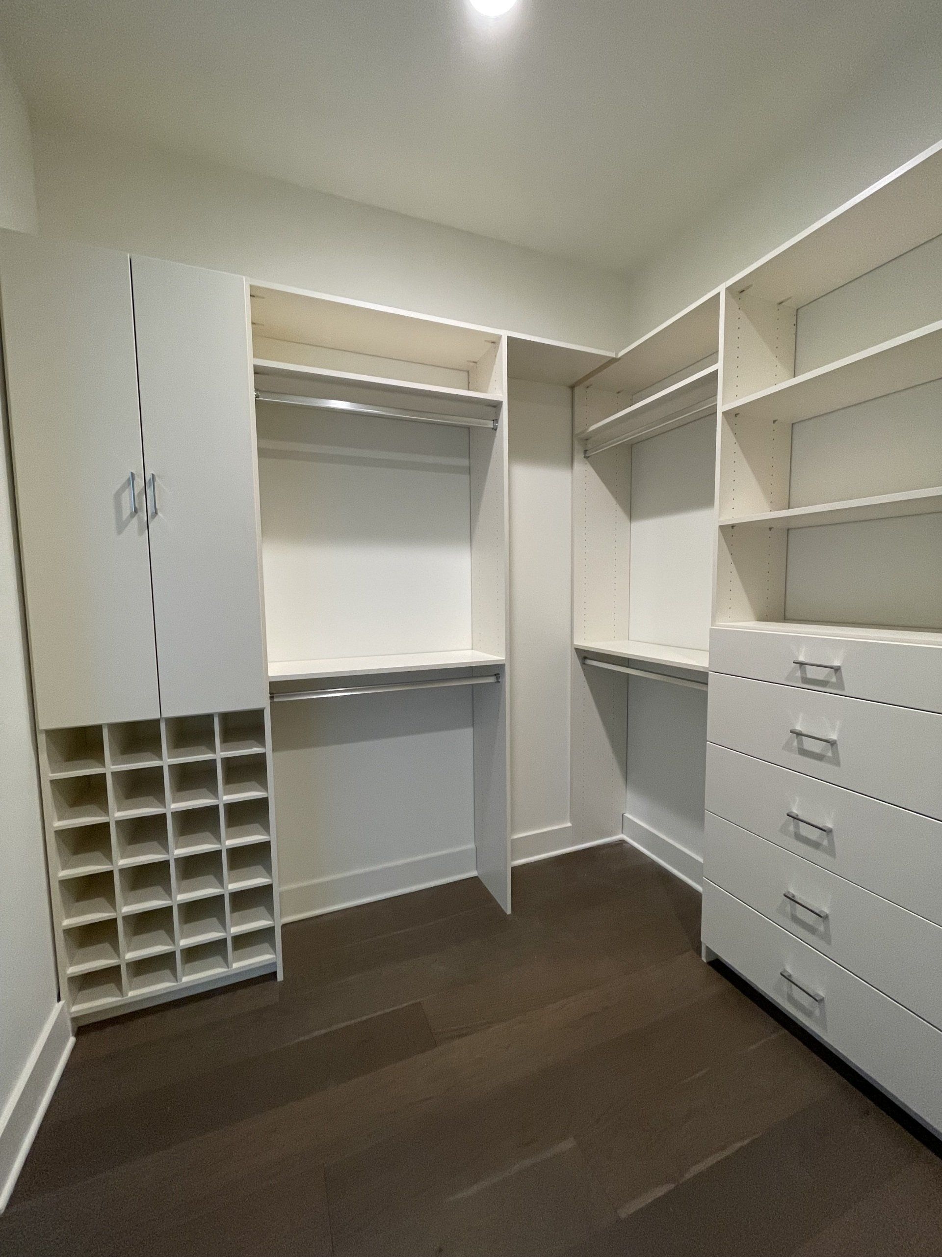 A walk in closet with lots of shelves and drawers