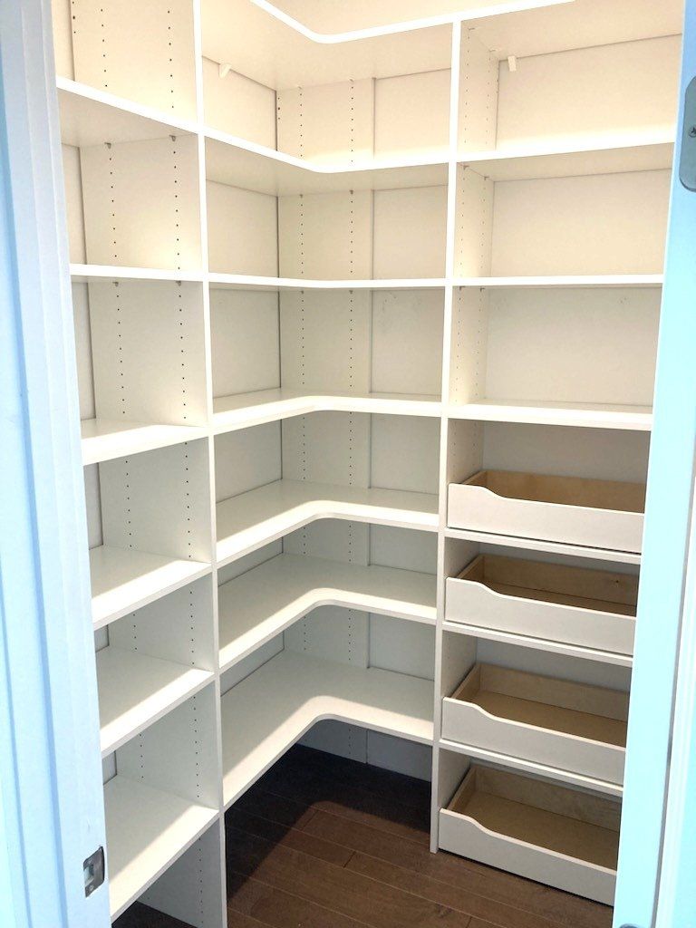 A walk in pantry with lots of shelves and drawers