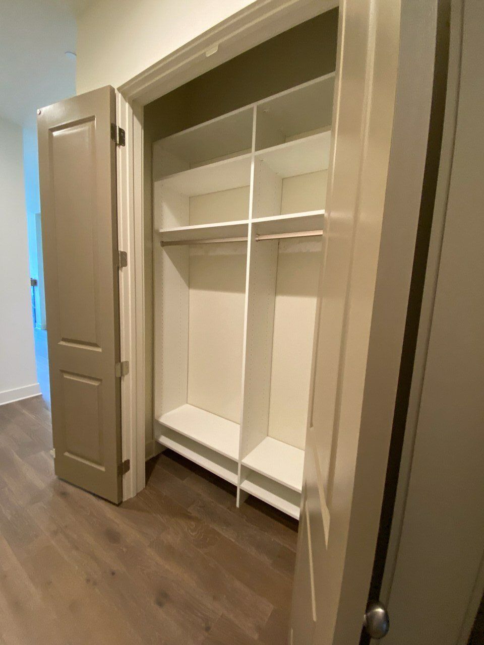 A closet with a lot of shelves and a door open.