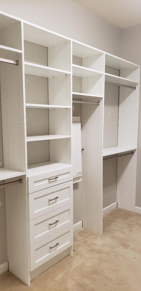 A walk in closet with lots of shelves and drawers.