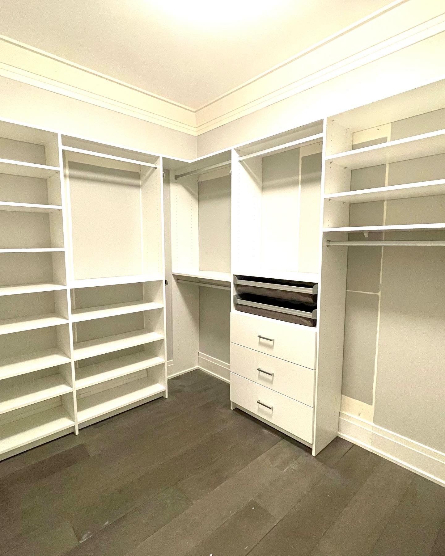 A walk in closet with lots of shelves and drawers.