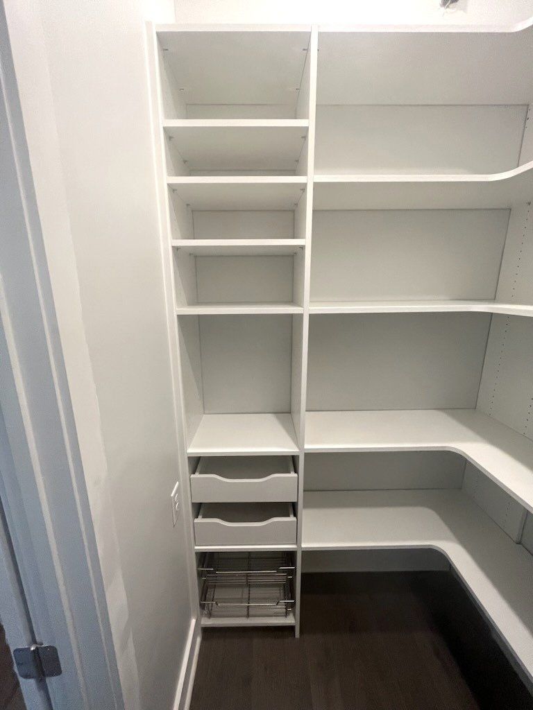 A walk in closet with lots of shelves and drawers.