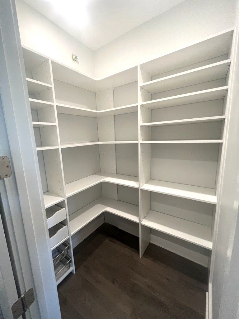 A walk in closet with lots of shelves and drawers.
