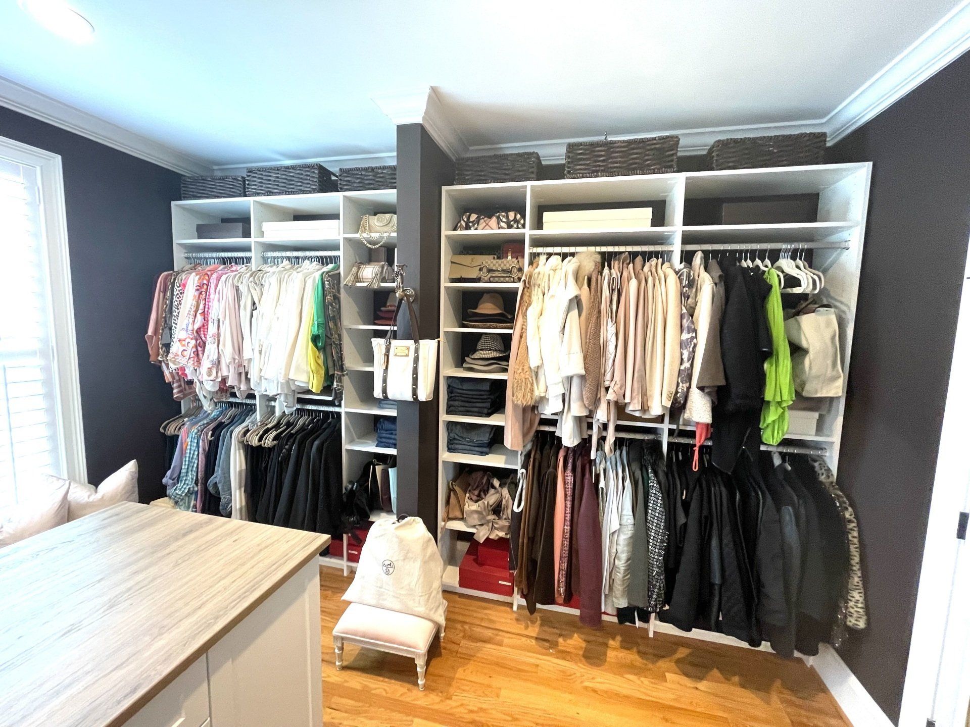 A large walk in closet filled with lots of clothes.