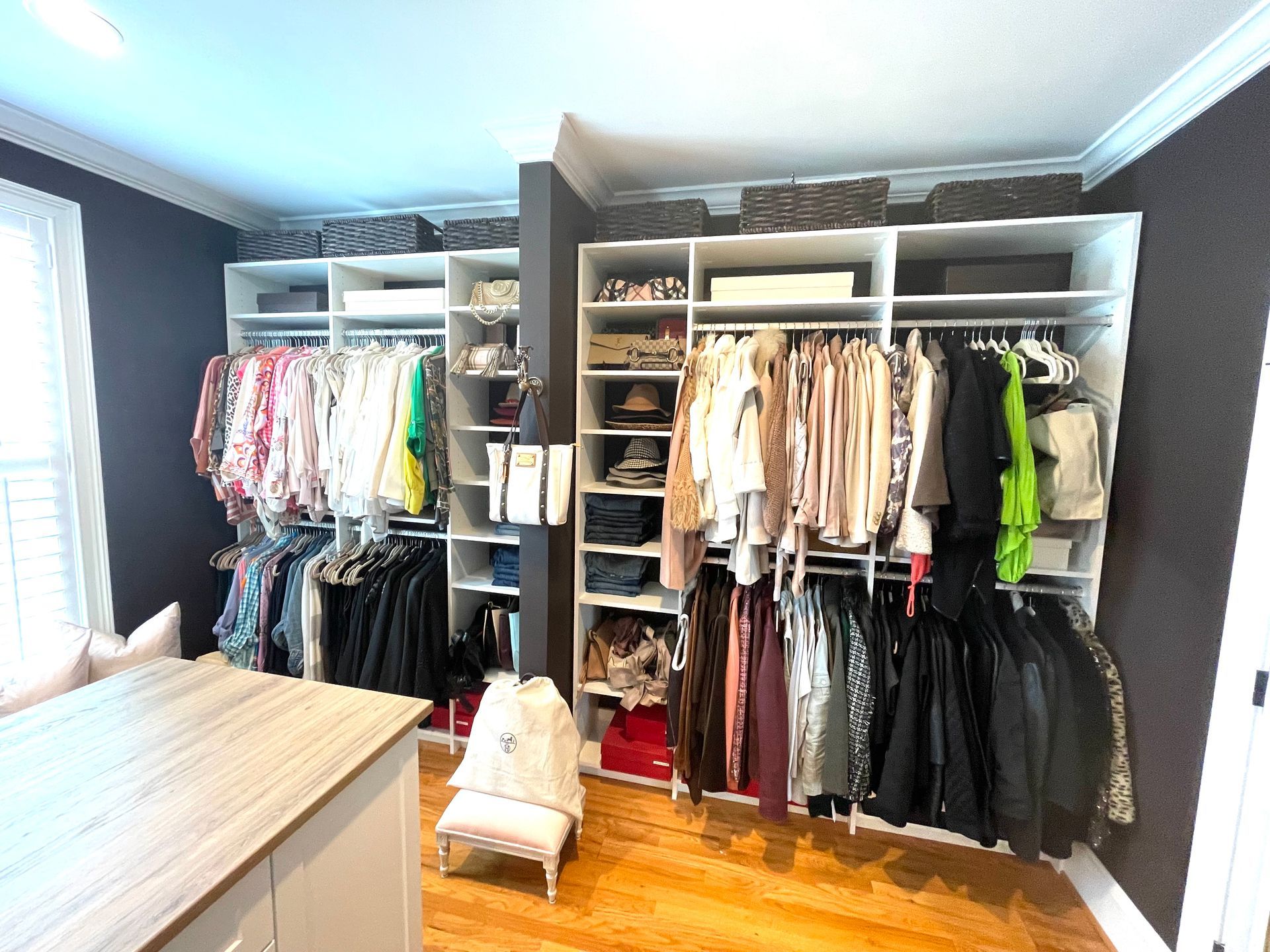 A walk in closet filled with lots of clothes and shoes.
