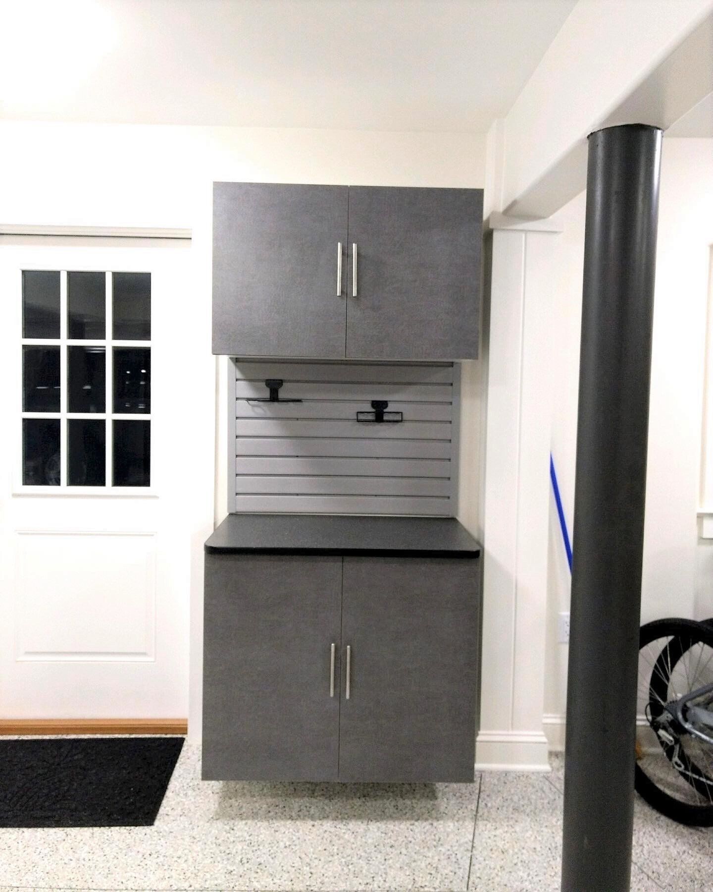A bicycle is parked in a garage next to a gray cabinet