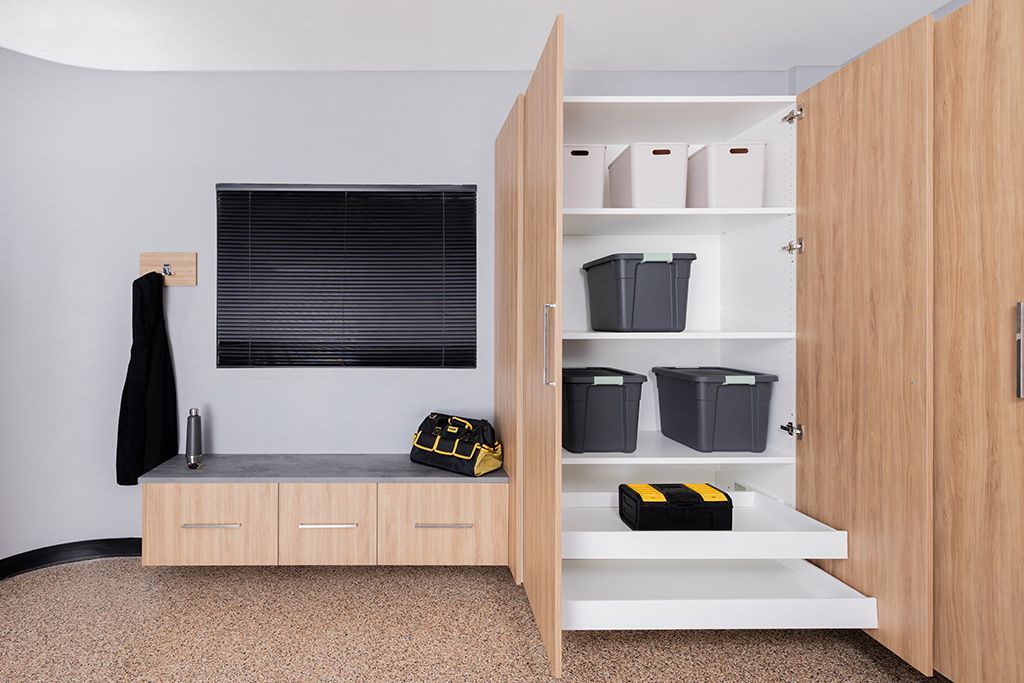 Modern entryway with built-in wood storage cabinets, shelves, and a wall-mounted TV in a minimalist room