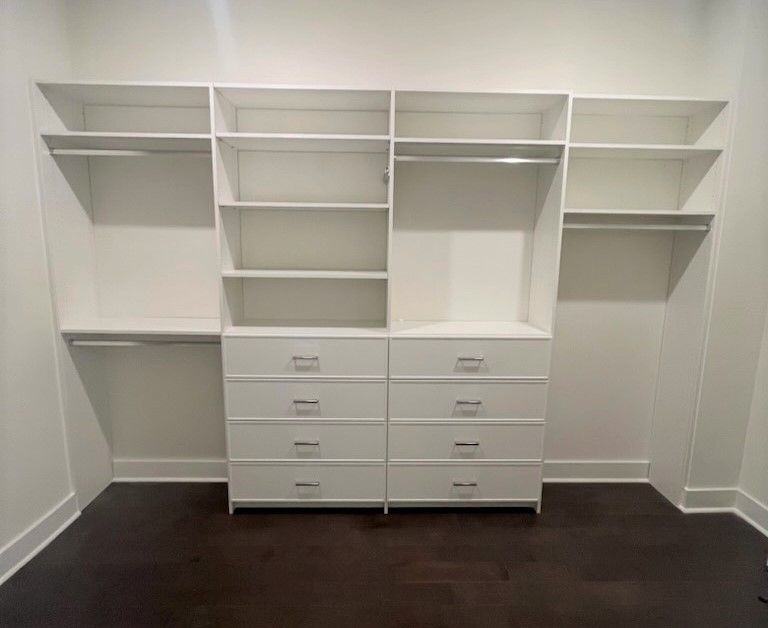 A walk in closet with lots of shelves and drawers.