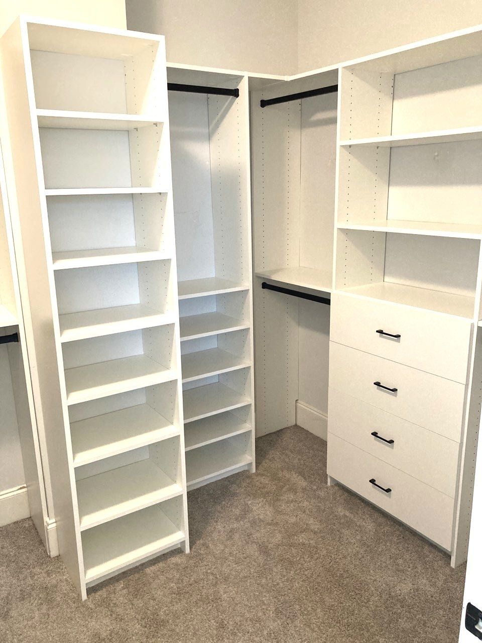 A walk in closet with lots of shelves and drawers.