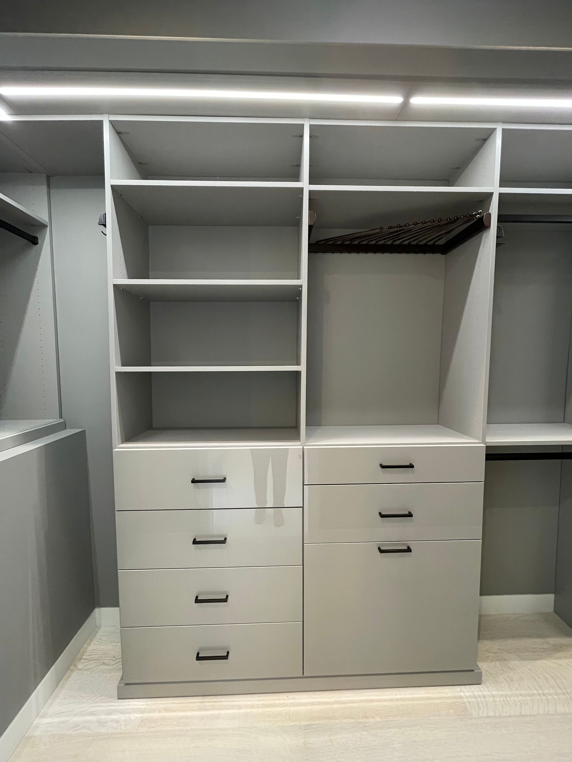 A walk in closet with lots of shelves and drawers.