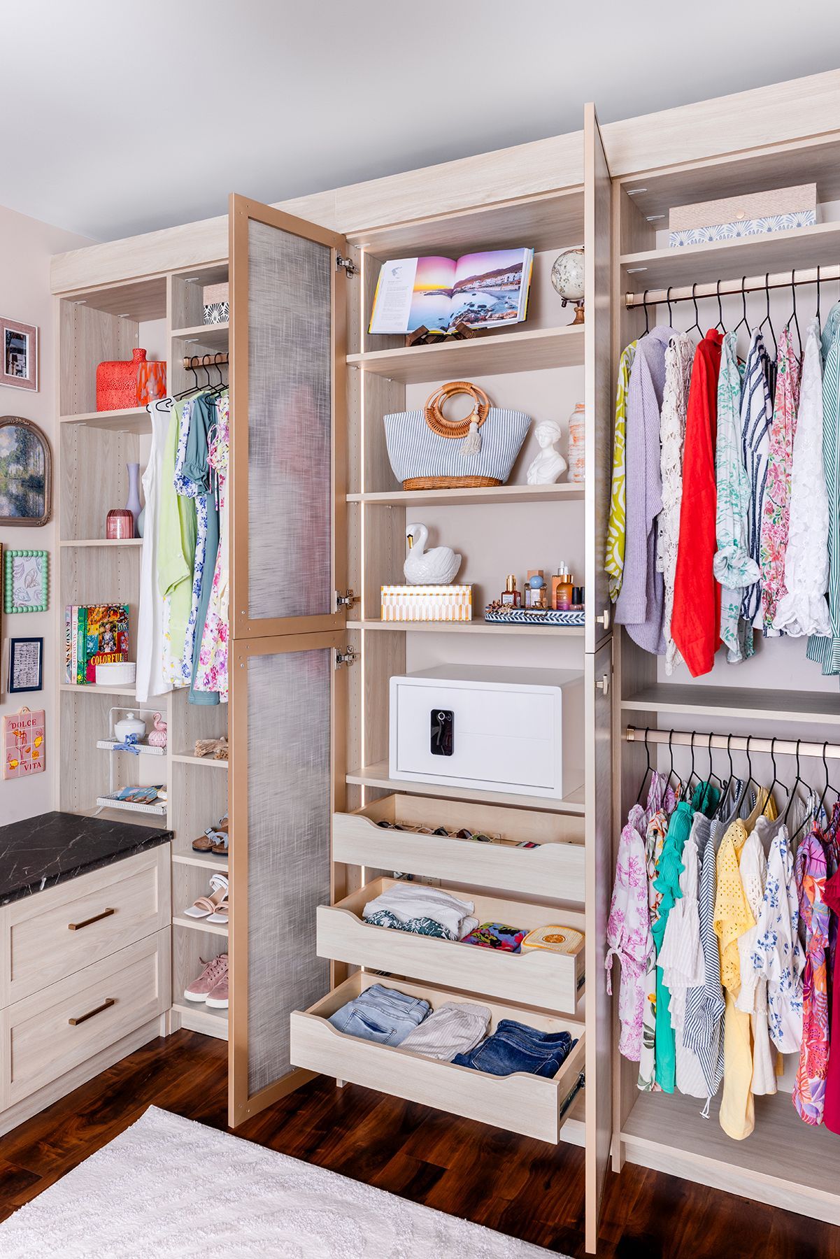 Walk-in closet with open wooden shelves, hanging clothes, drawers, and woven storage bins