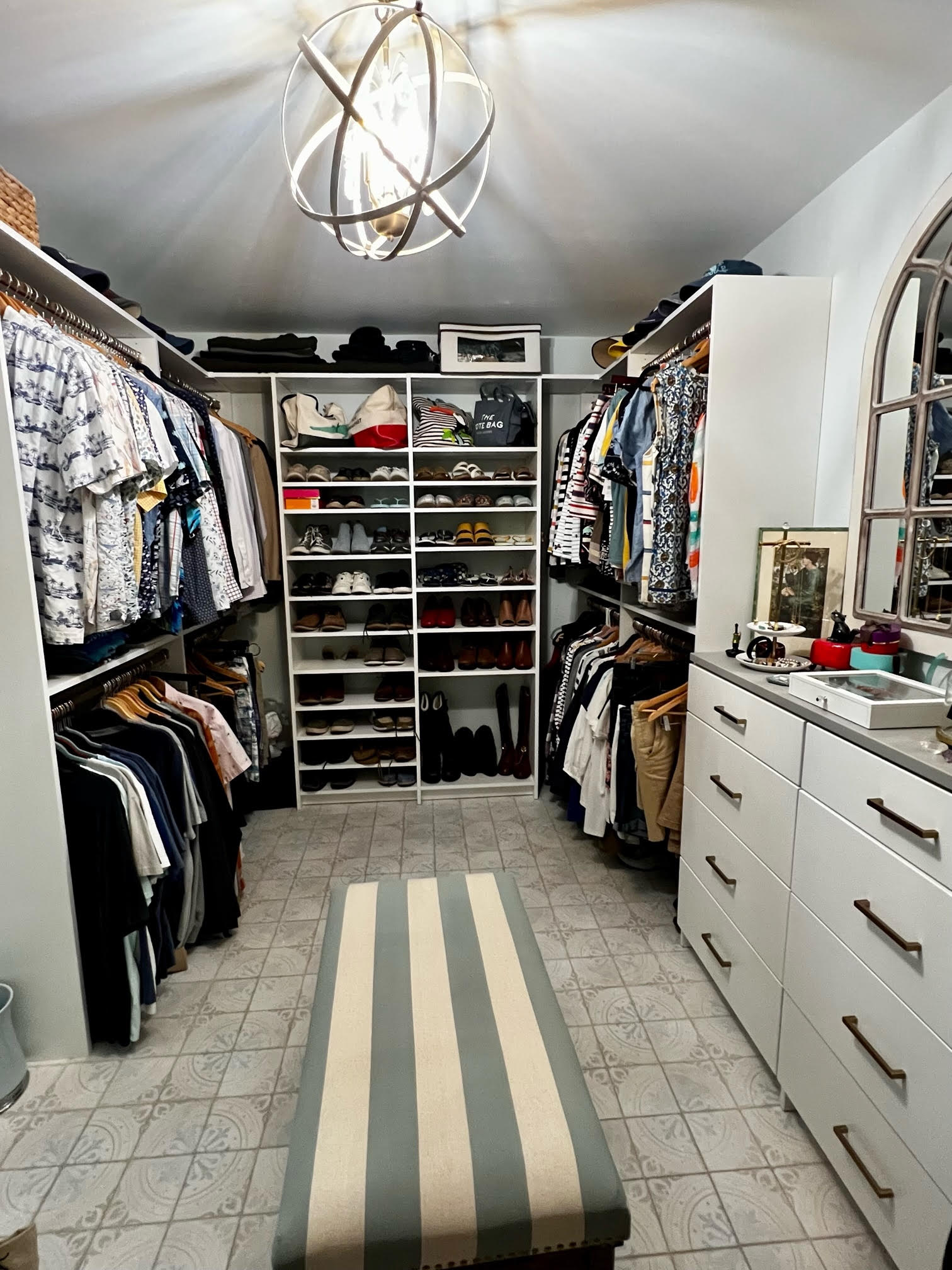 A walk in closet filled with lots of clothes and shoes.