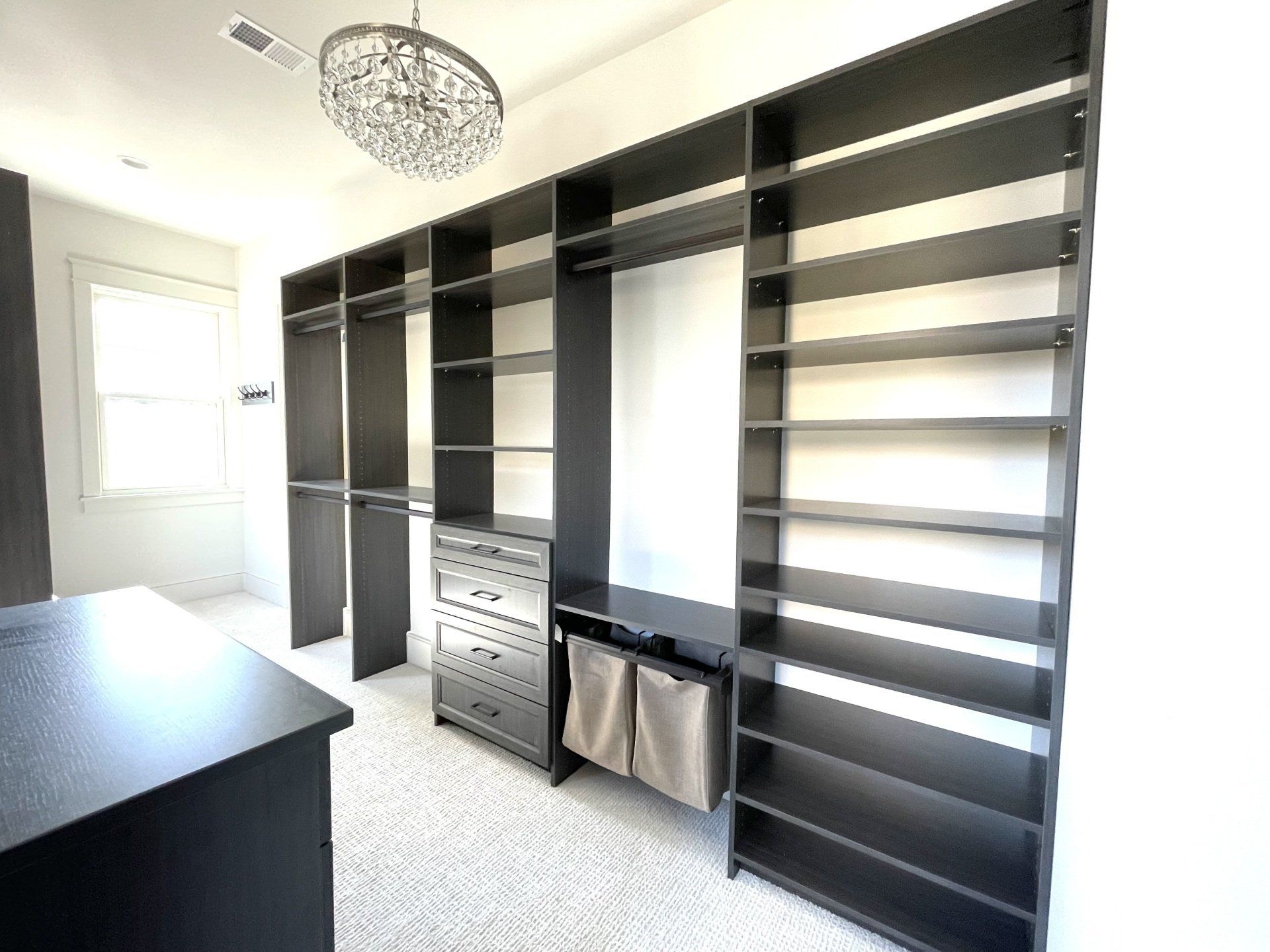 A walk in closet with lots of shelves and drawers.