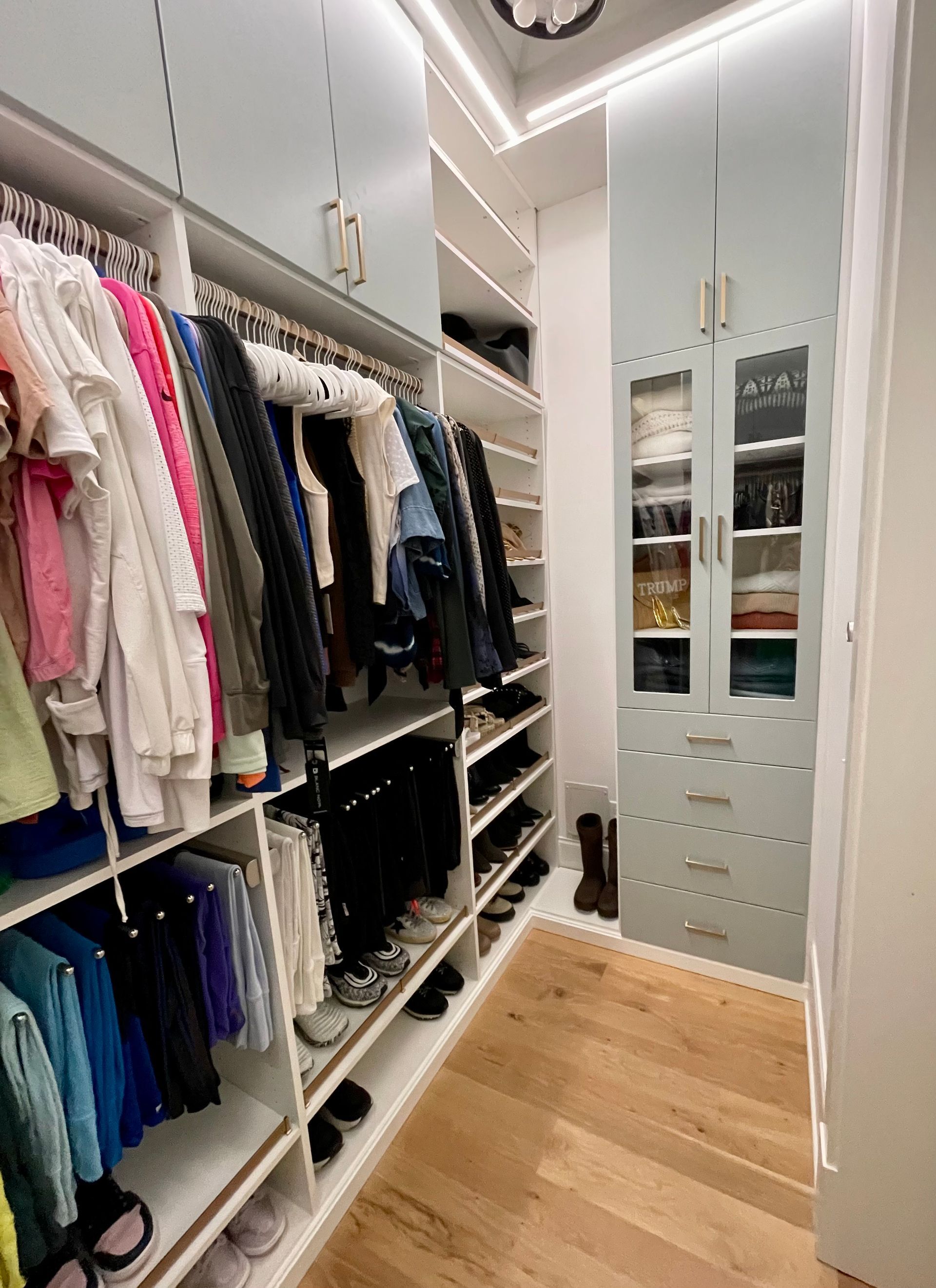 A walk in closet filled with lots of clothes and shoes.