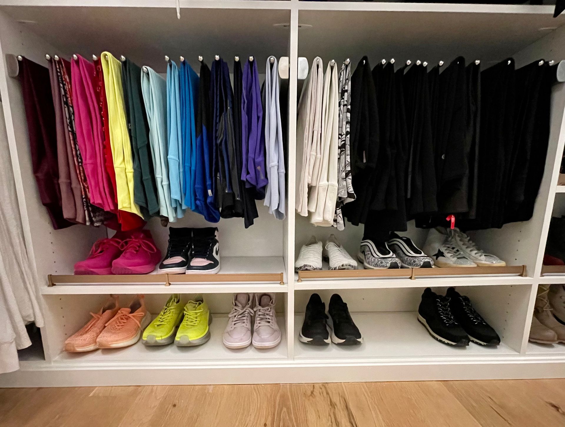 A closet filled with lots of clothes and shoes.