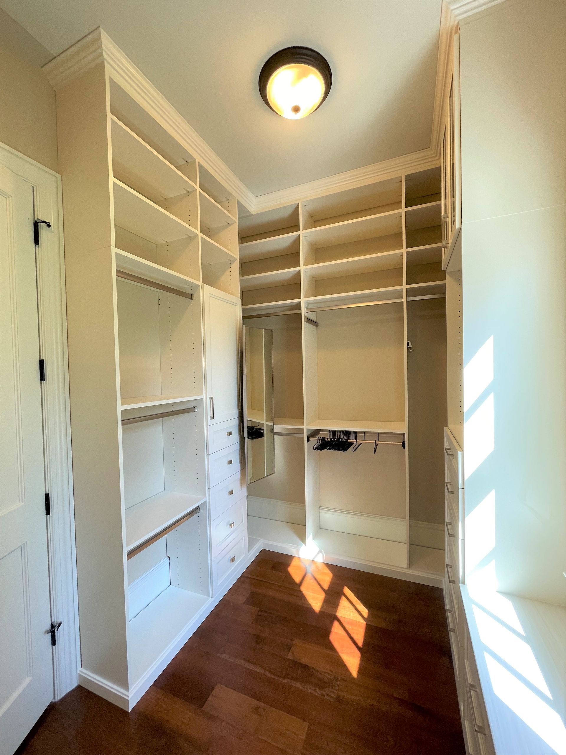 A walk in closet with lots of shelves and drawers