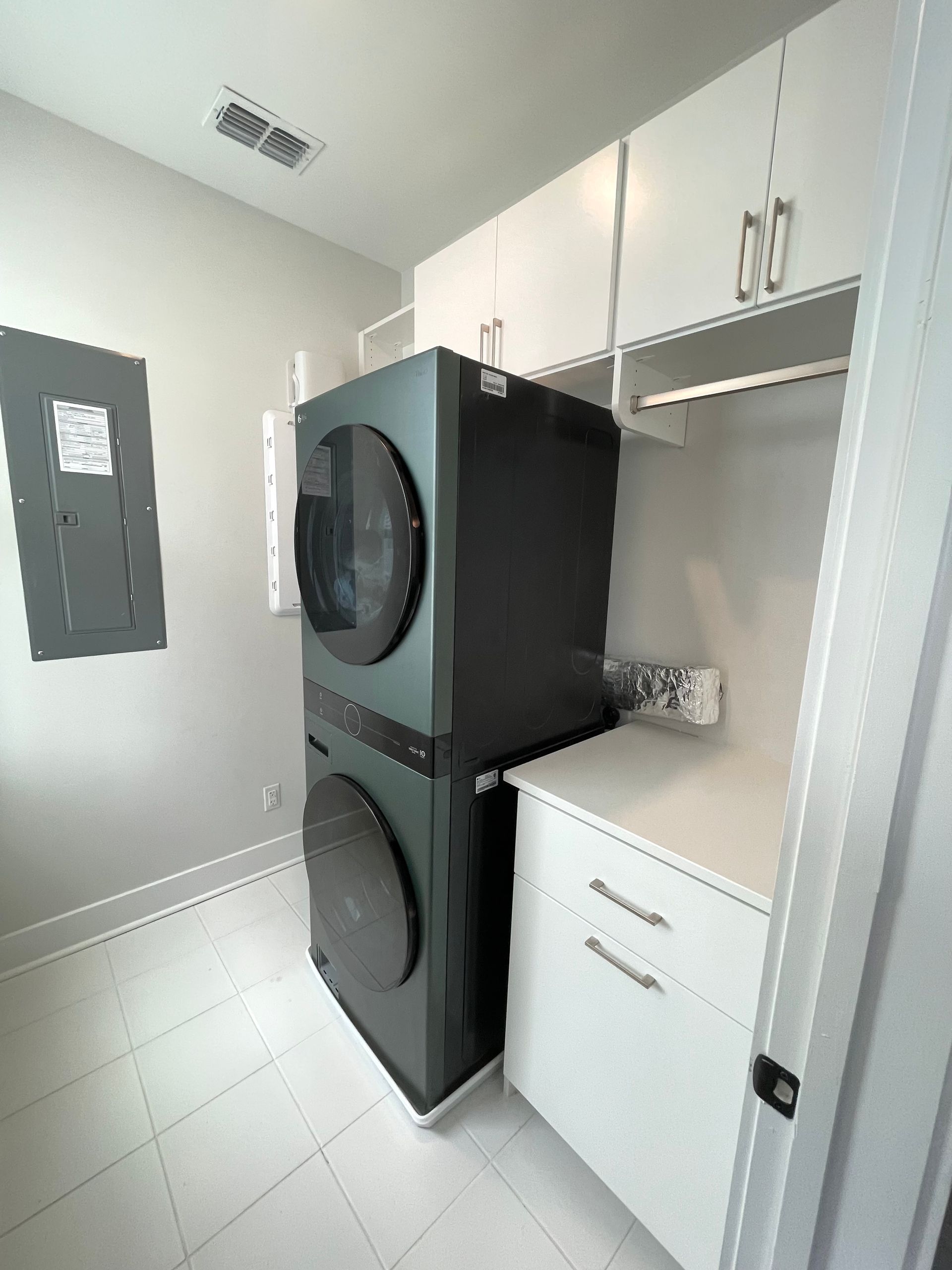 A laundry room with a washer and dryer stacked on top of each other.