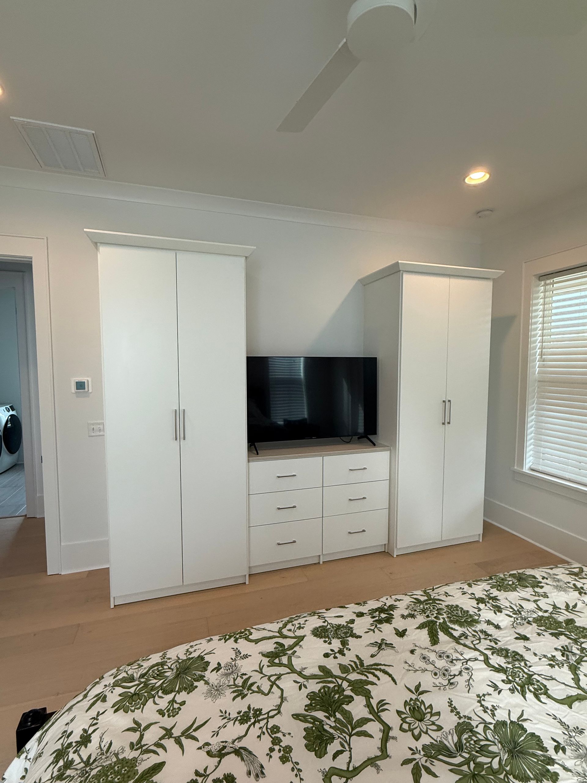 A bedroom with a bed , dresser , and television.