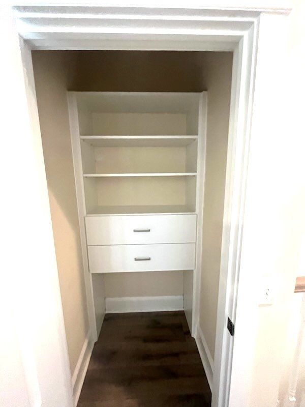 A small closet with shelves and drawers in a house.