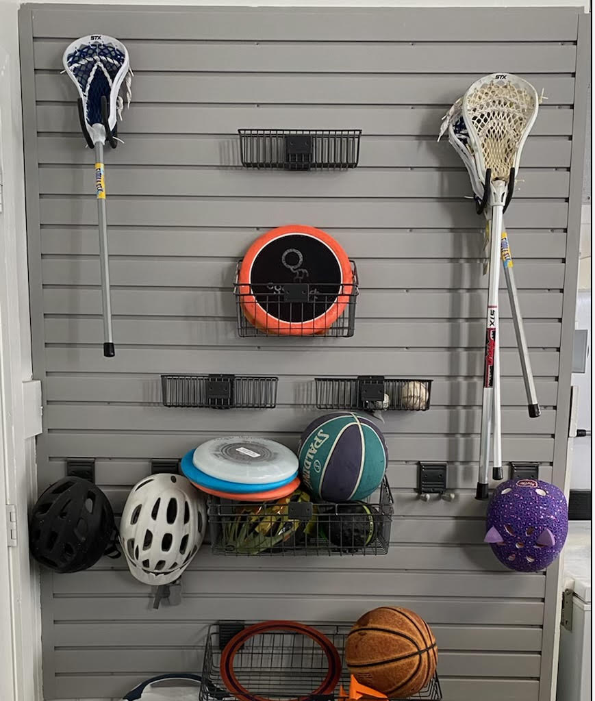 A wall with a bunch of sports equipment hanging on it.