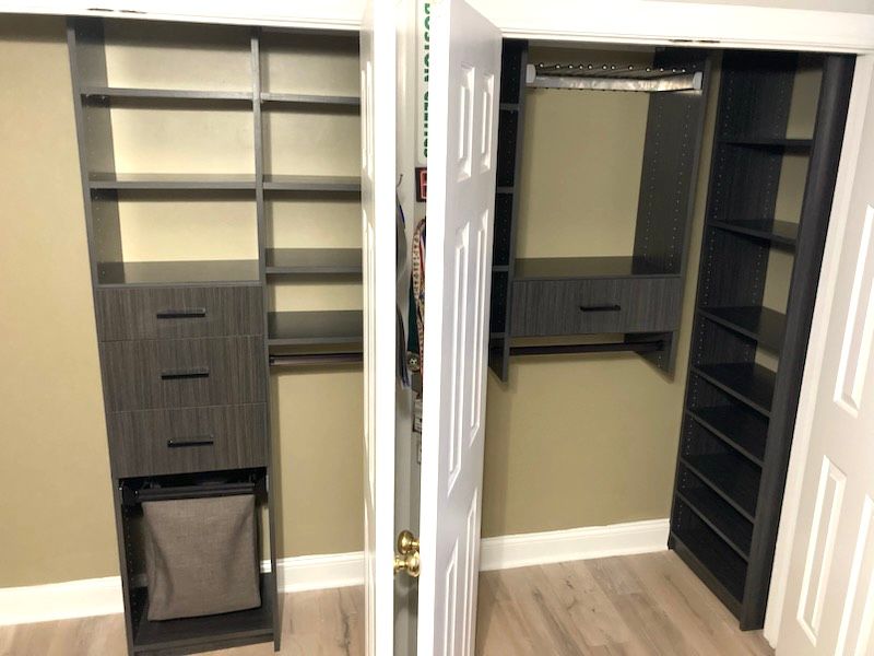 A walk in closet with shelves drawers and a laundry basket